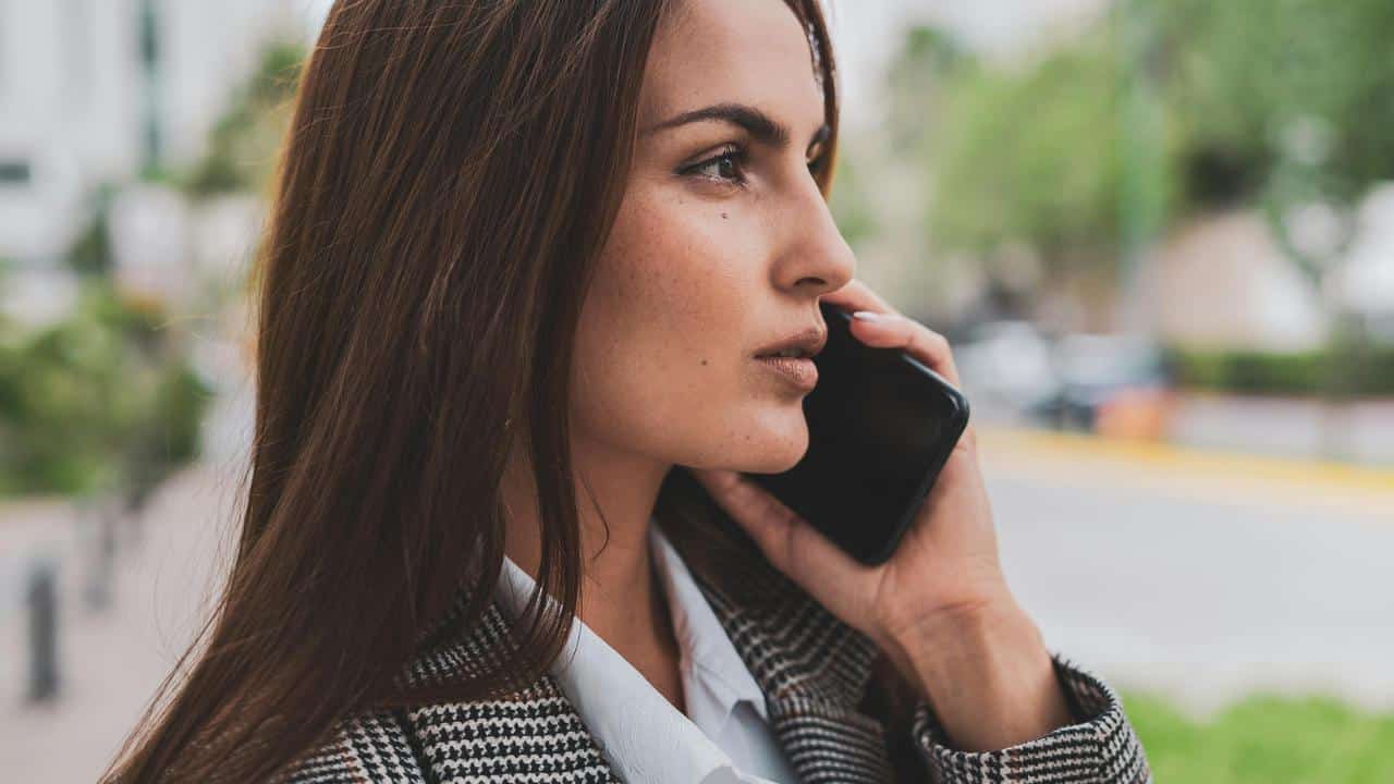 A woman talking on a smartphone outdoors.