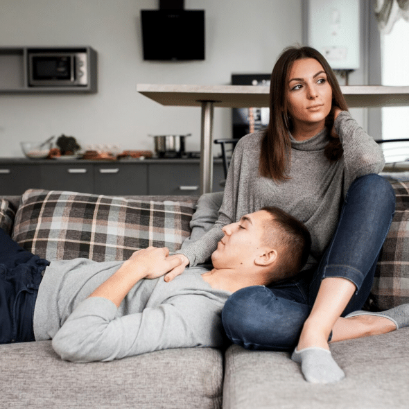 A lazy man resting his head on woman’s lap