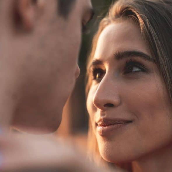 A woman staring into a man’s eyes while smiling.