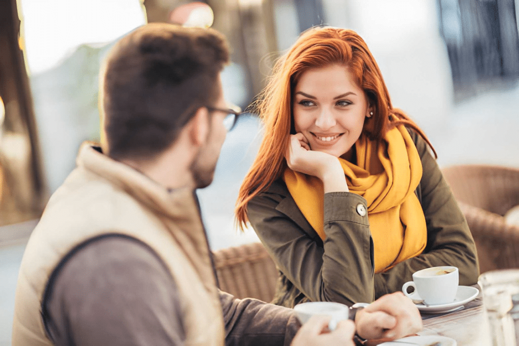 Young couple in love sitting at the cafe table outdoors