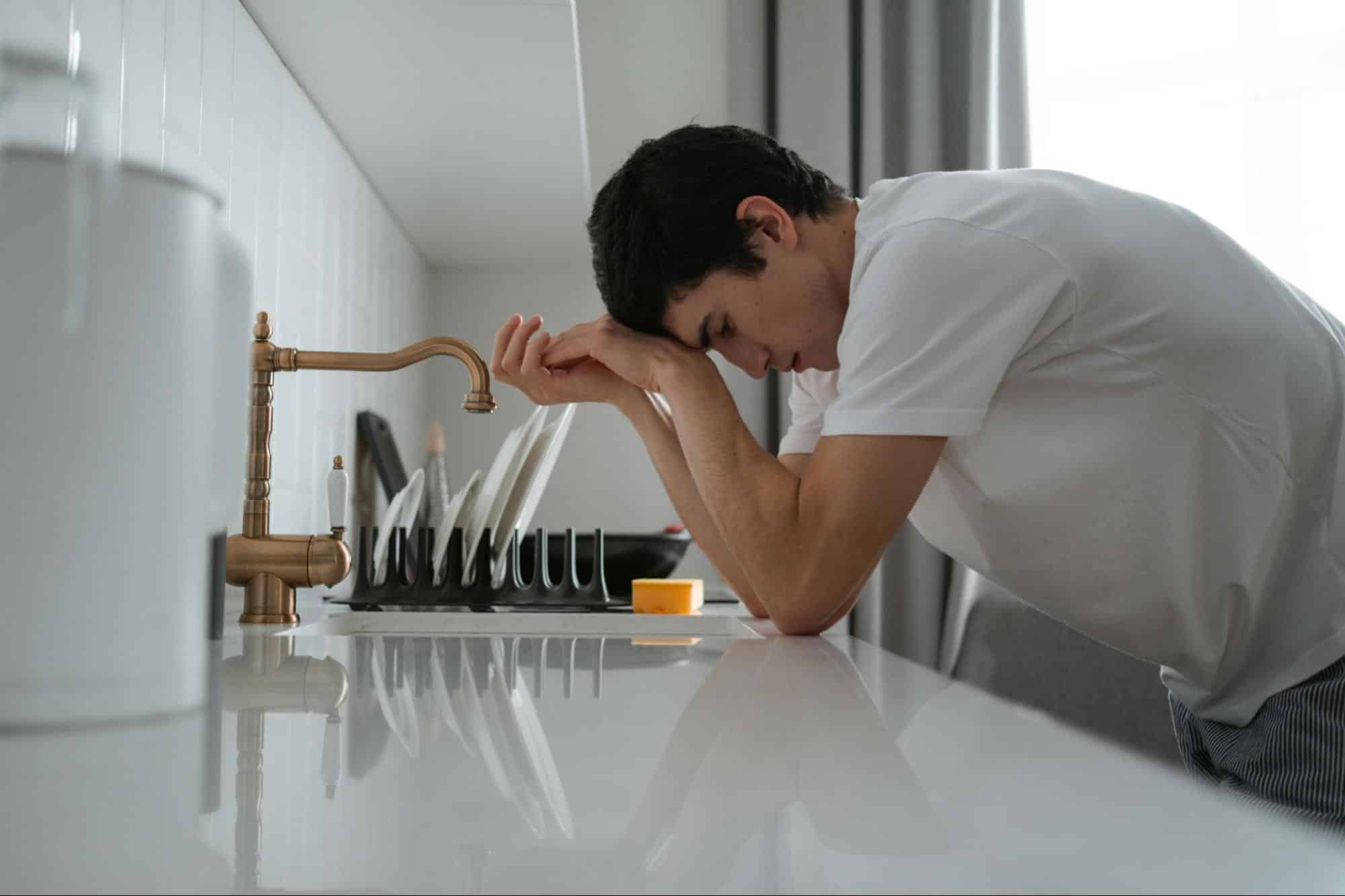 A man leaning on the kitchen counter.