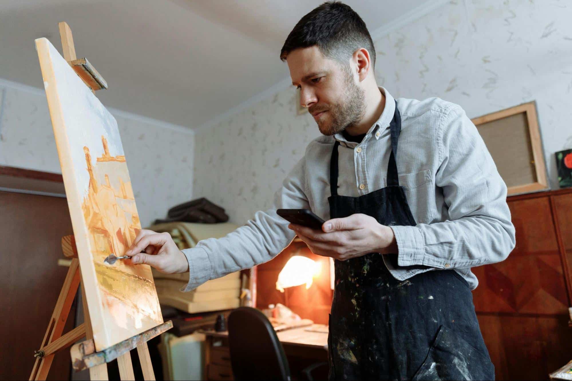 A man painting with a palette knife.