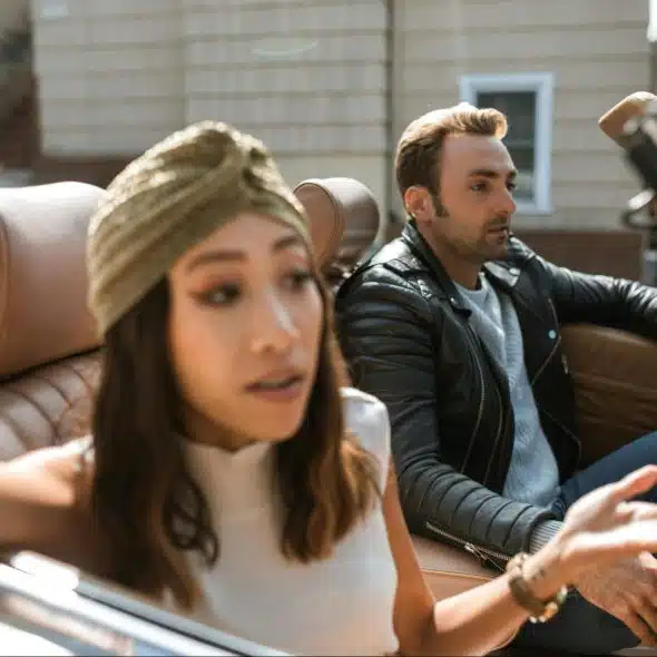 A woman talking to a man inside the car.