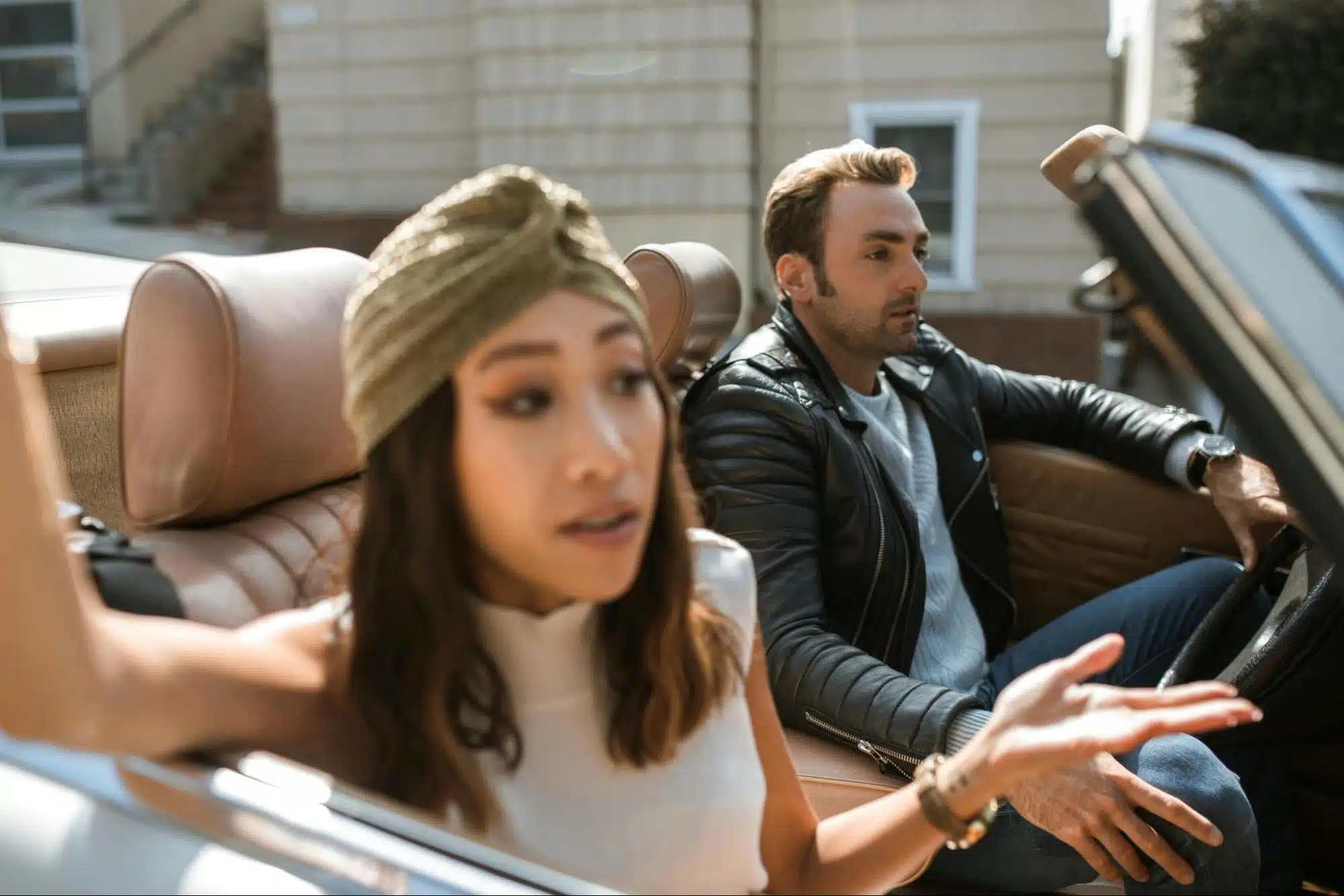 A woman talking to a man inside the car.