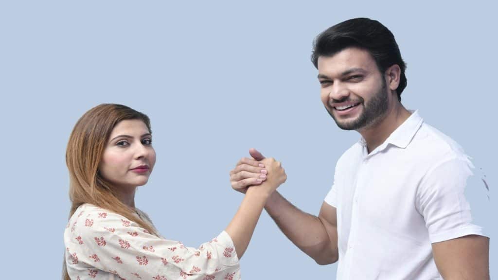 A man and woman posing for a picture while holding hands.