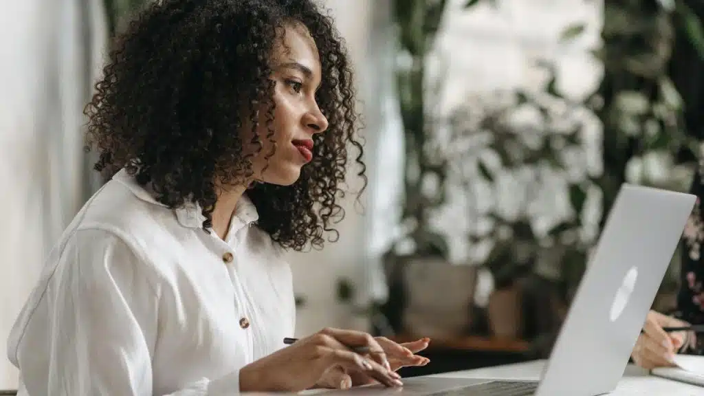A woman working on a laptop at a desk.