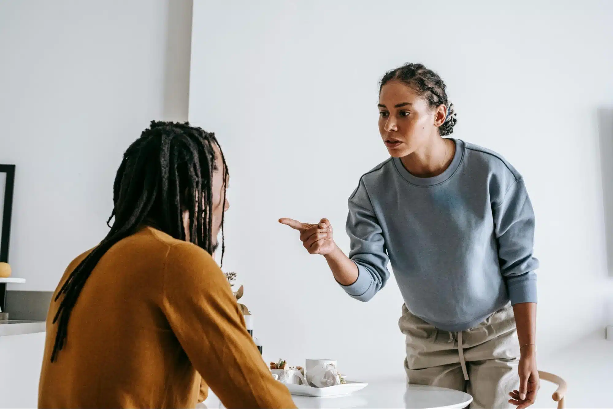 An angry woman pointing to a man.