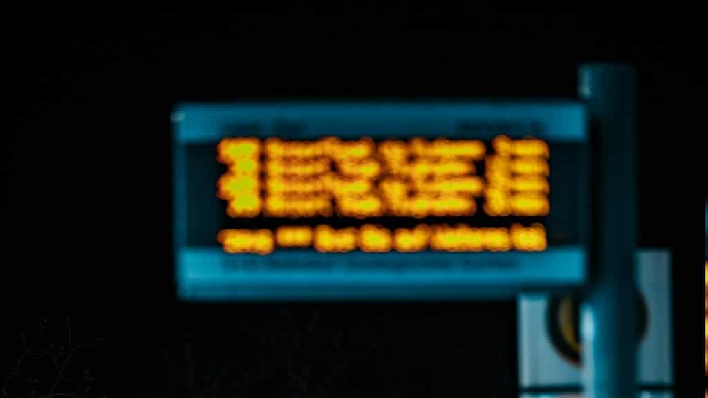 Blue and yellow-lighted street sign during nighttime.