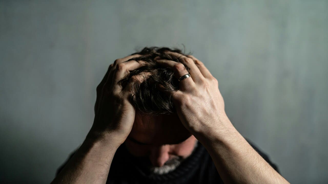 A couple with his hands on his head