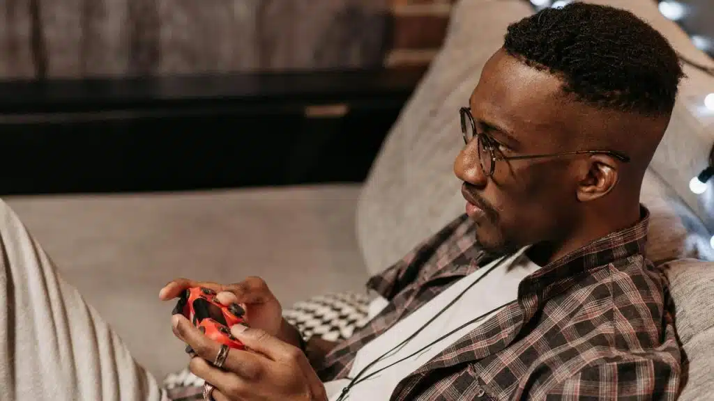 A man sitting on a couch playing a video game.
