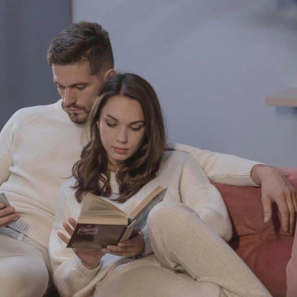 A couple sits on a couch