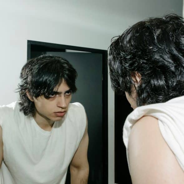 An angry man looking at himself in the mirror.