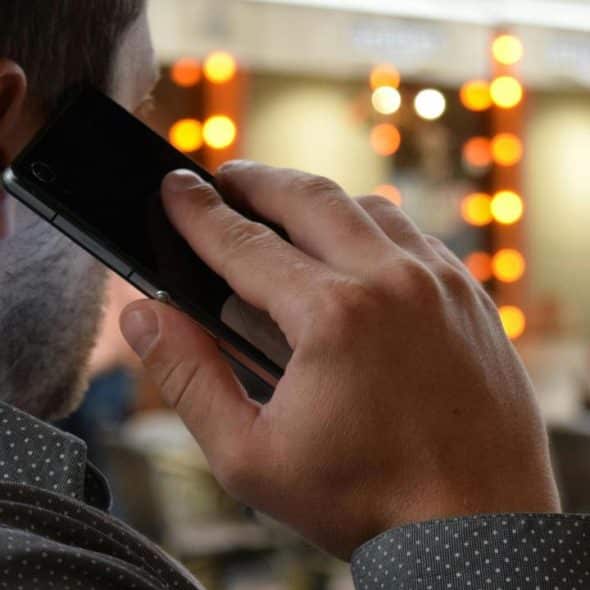 A man talking on a phone in a café.