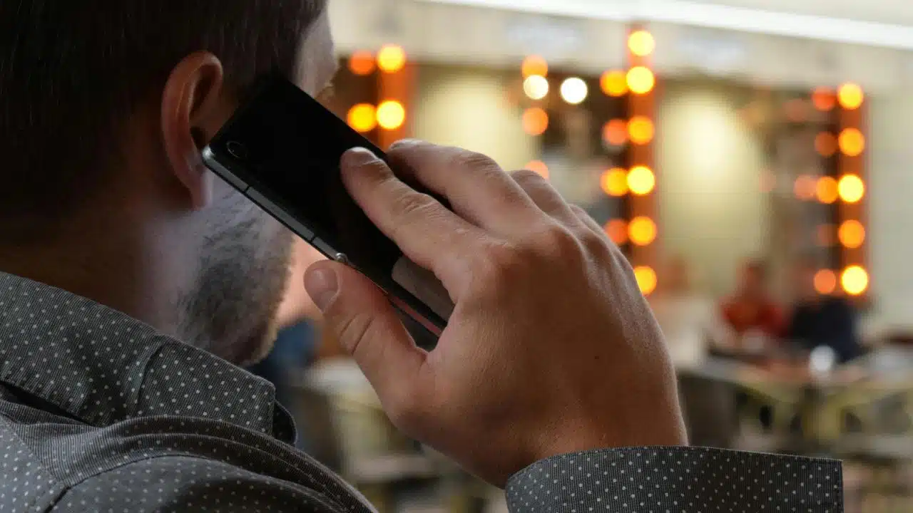 A man talking on a phone in a café.
