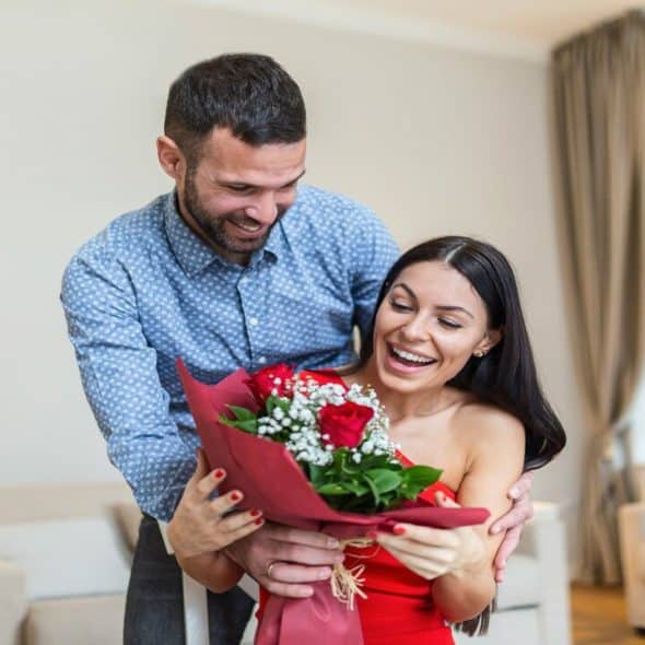 A man offering a woman a bouquet of roses