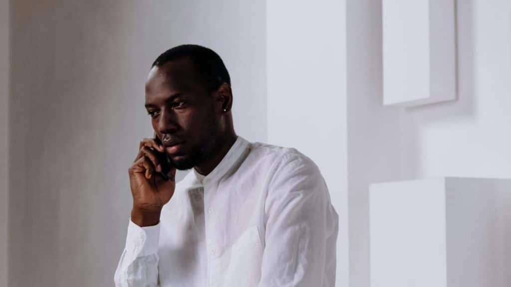 A man in a white shirt talking on a phone.