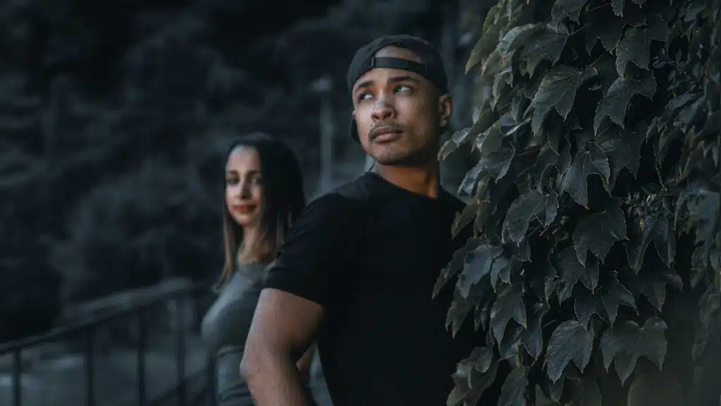 Man in a black crewneck t-shirt standing beside a woman in a black crewneck t-shirt.