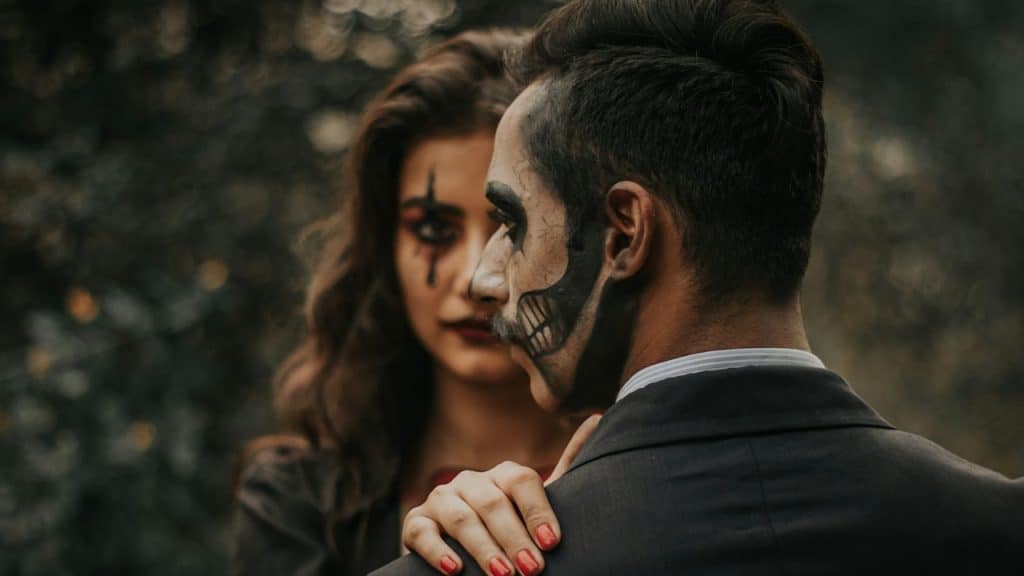 A man and woman with Halloween paint on their faces.