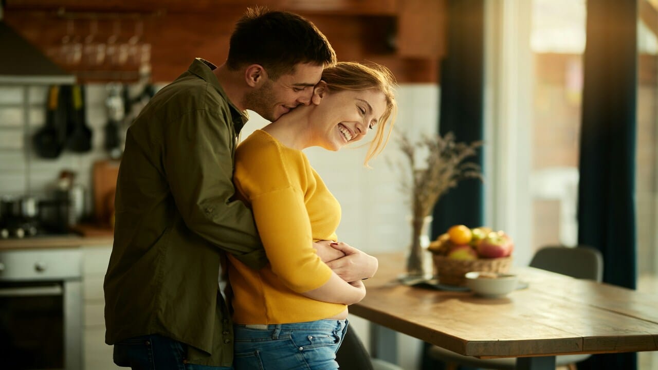 A couple hugging in the kitchen