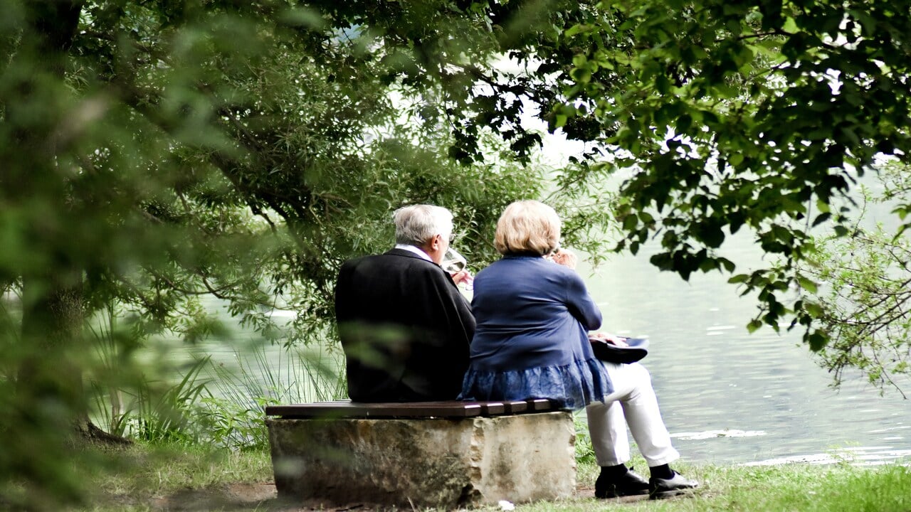 An older couple watching the lake together