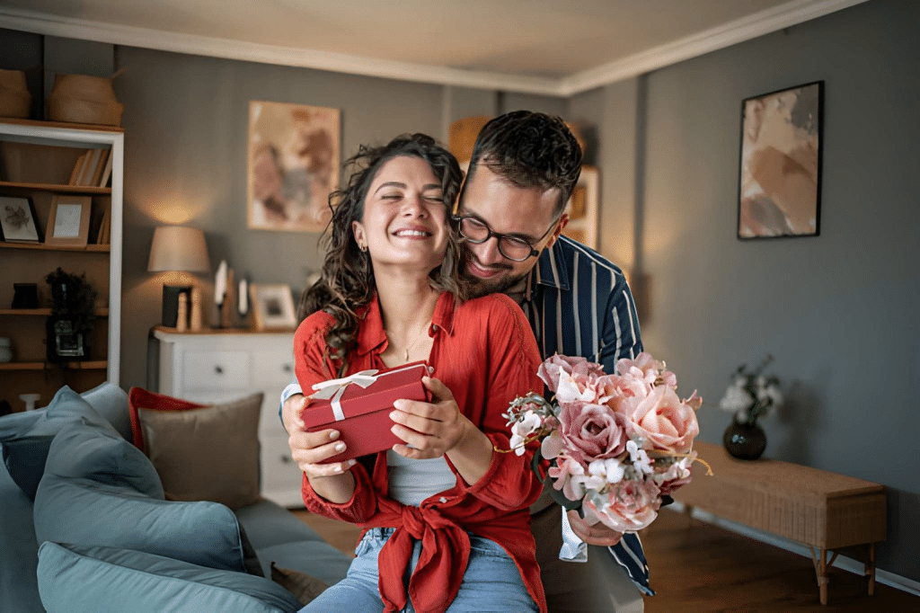 Man surprising his beloved girlfriend with a present and flowers