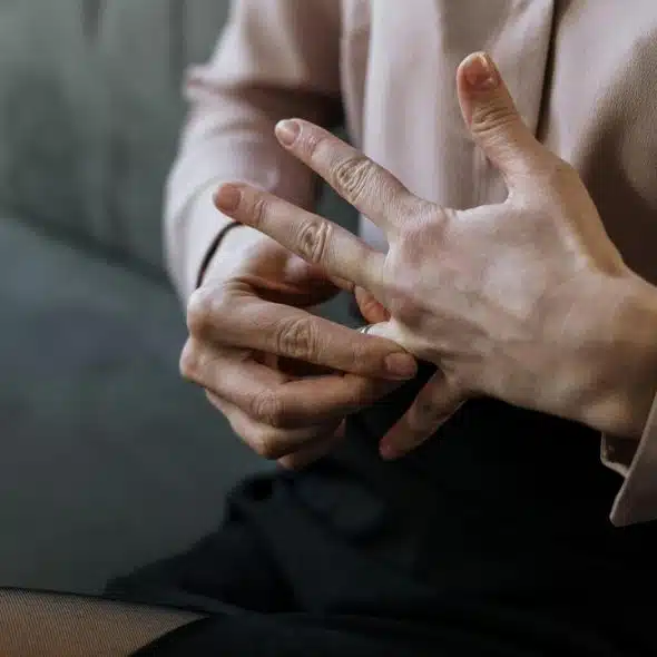 A person removing a ring from their finger.