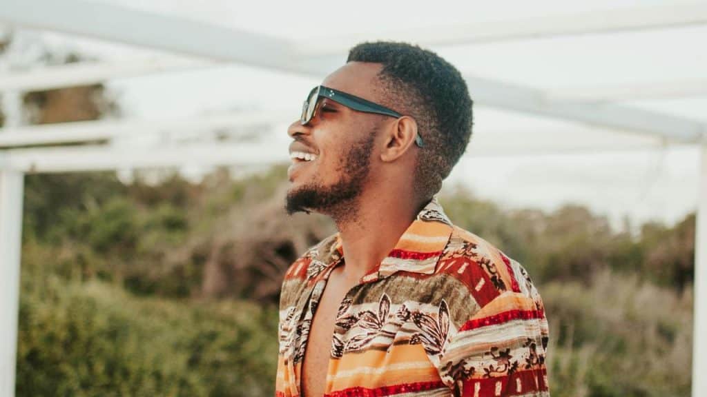 A smiling man wearing sunglasses outdoors.