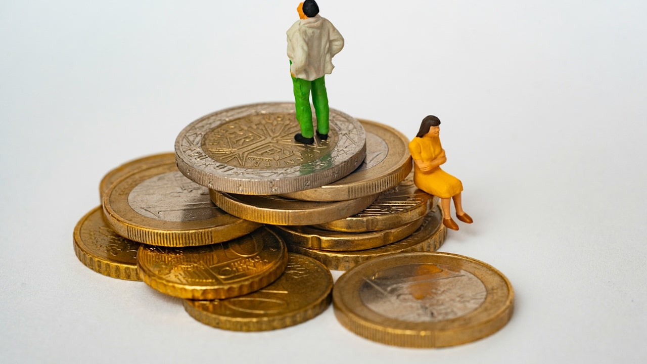 A toyman standing on the stake of coins and women sitting on the stake