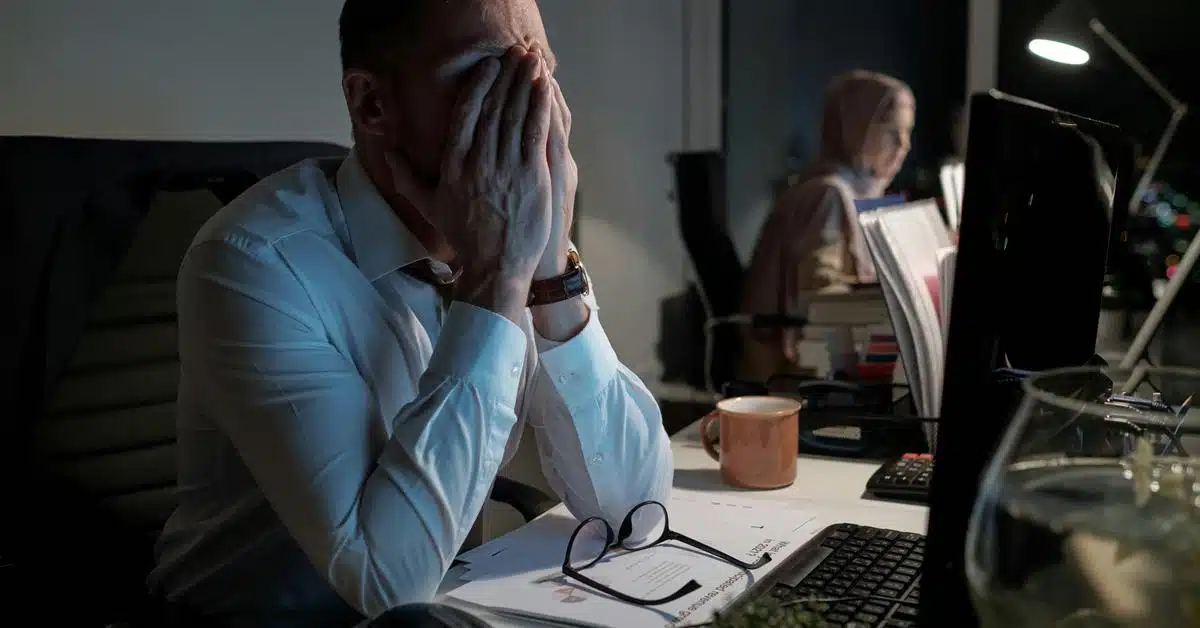 A tired man covering his face