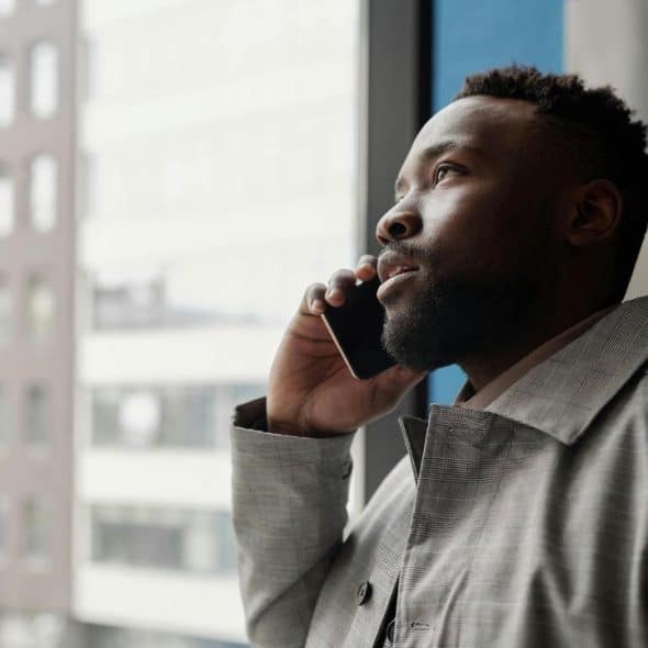 A man in a gray coat talking on a phone