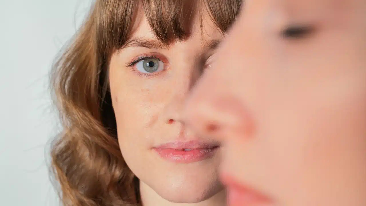 A women is seeing smiling to another women who is looking serious