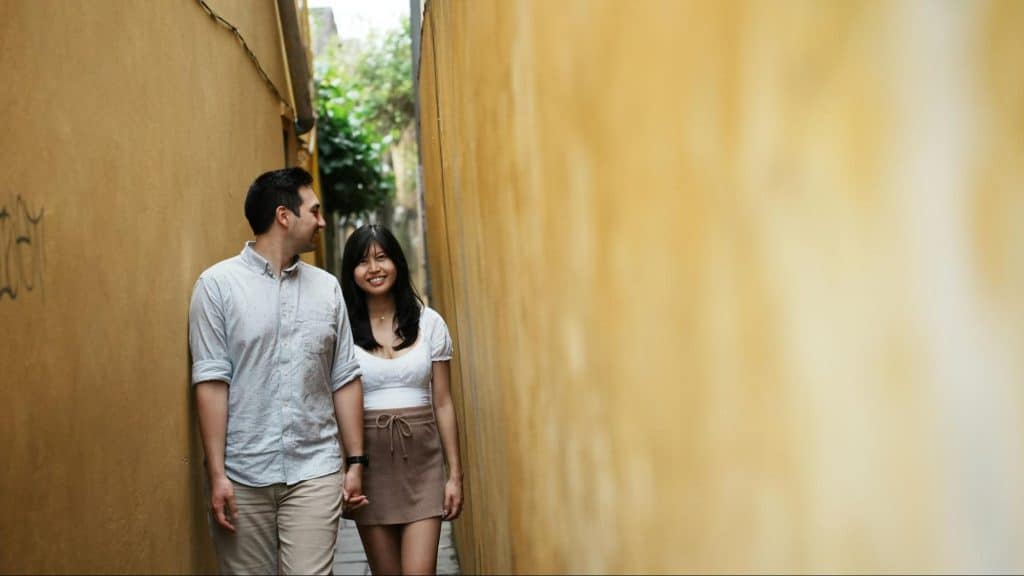 A man and woman walking while holding hands