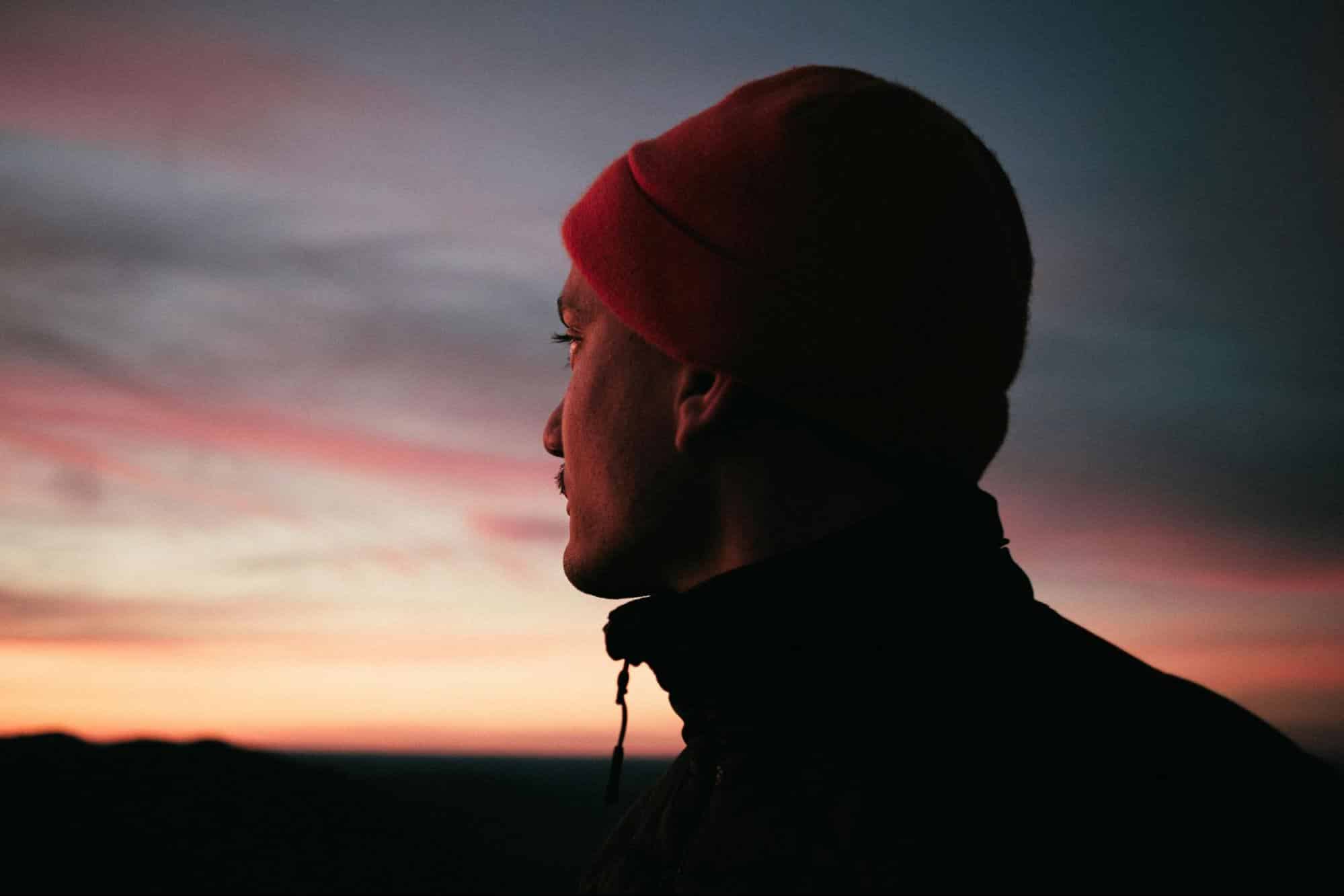 A man looking into a sunrise.