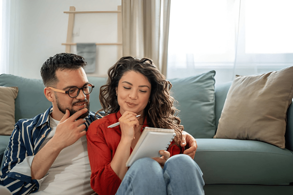 Young couple taking notes and planning their home finances together