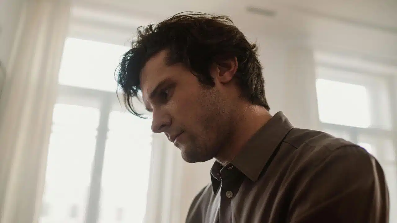 A man in a brown shirt looking down