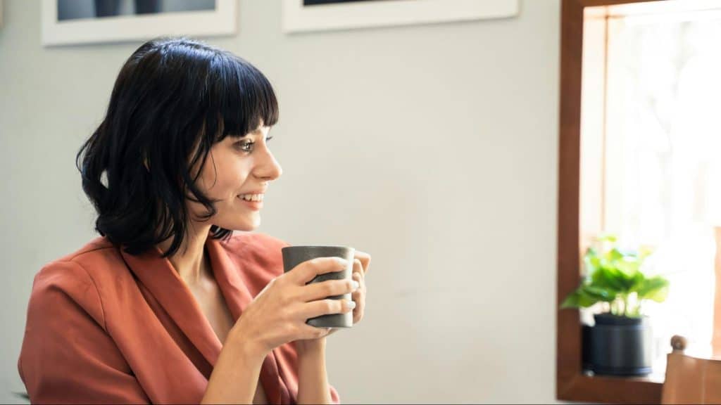 Woman smiling while drinking coffee
