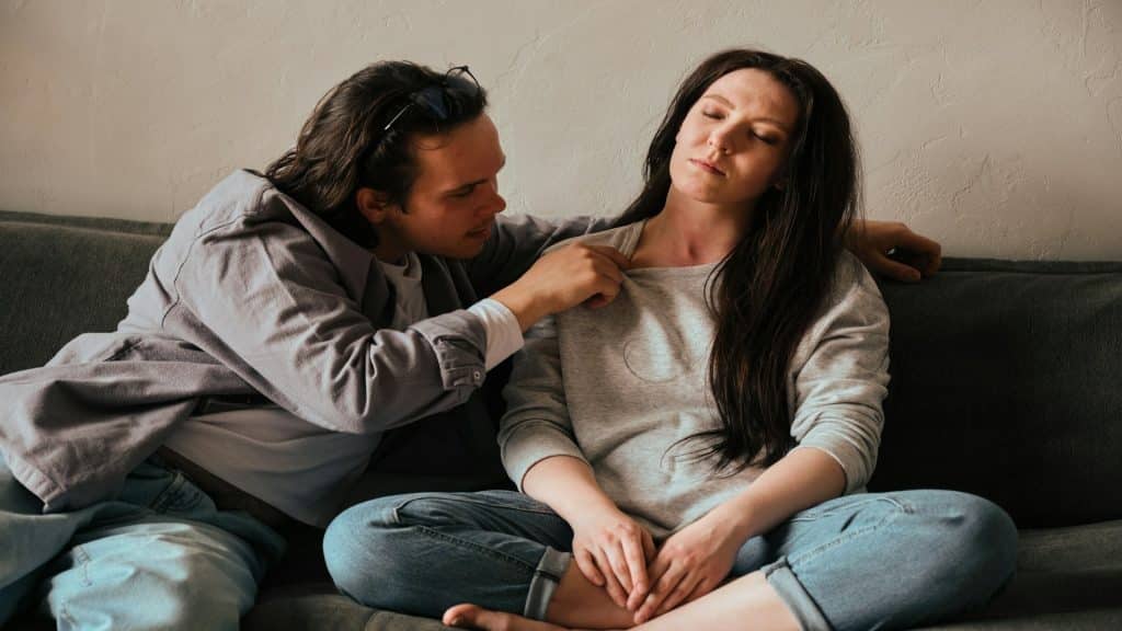 couple sitting very close but looking emotionally tense