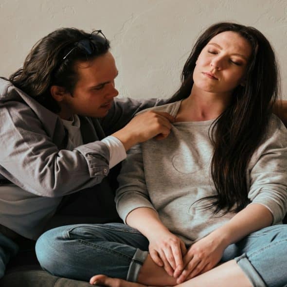 couple sitting very close but looking emotionally tense