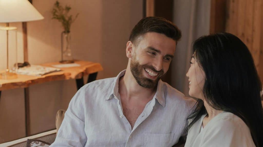 A couple sitting close together smiling at each other