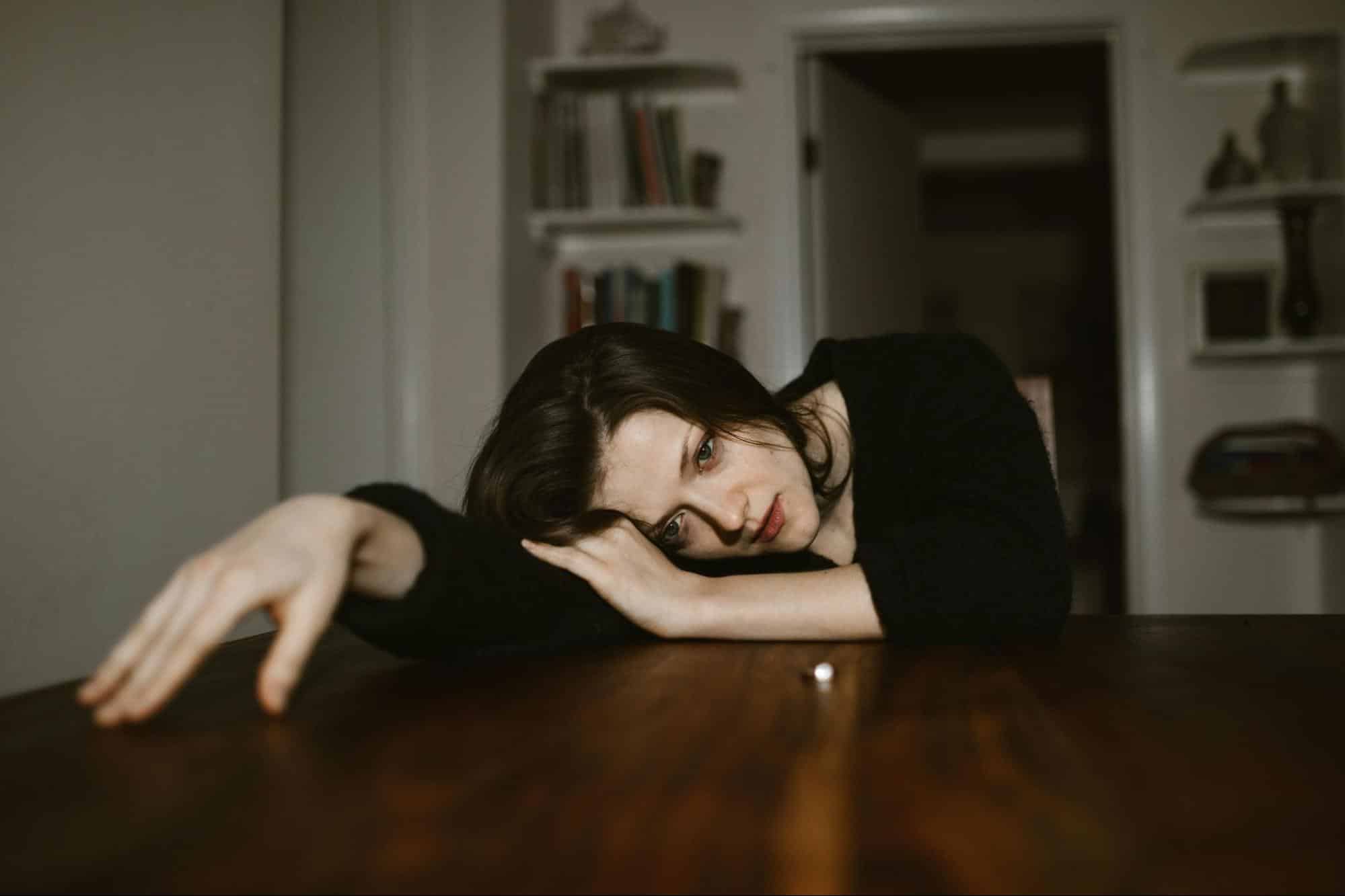A woman resting her head on a table.