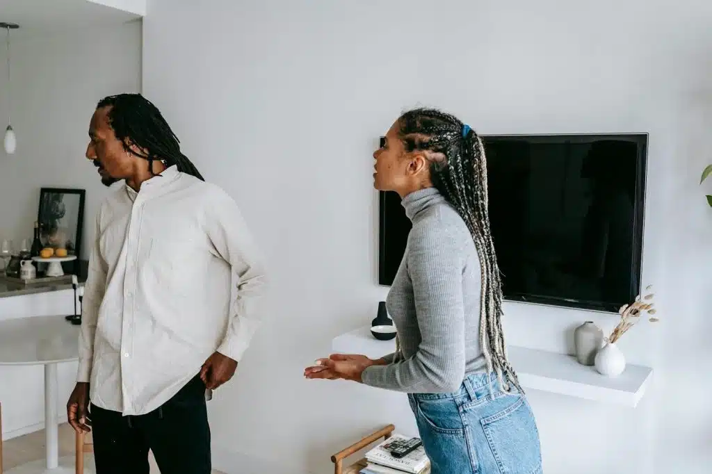 A woman looking confused as her partner looks away from her mid-conversation.