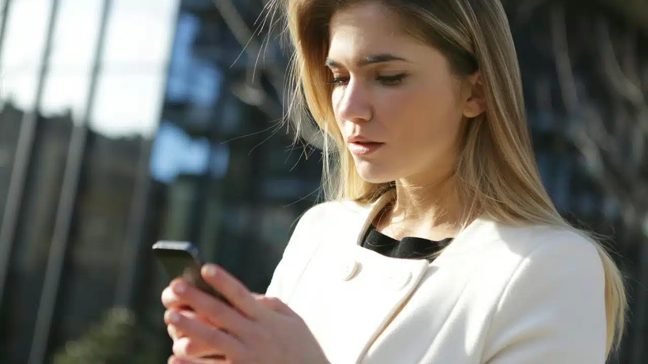A woman outdoors looking at her phone