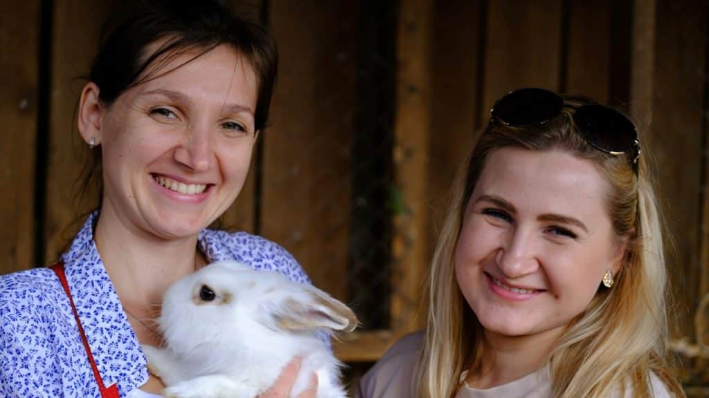 A woman holding a white rabbit in her arms.