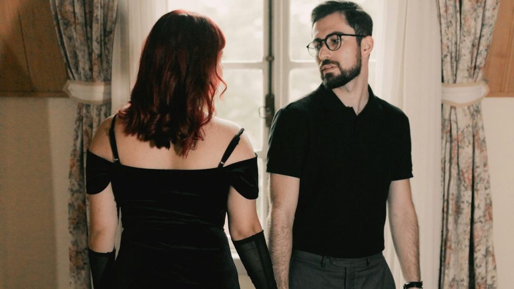 A man standing next to a woman in a black dress.