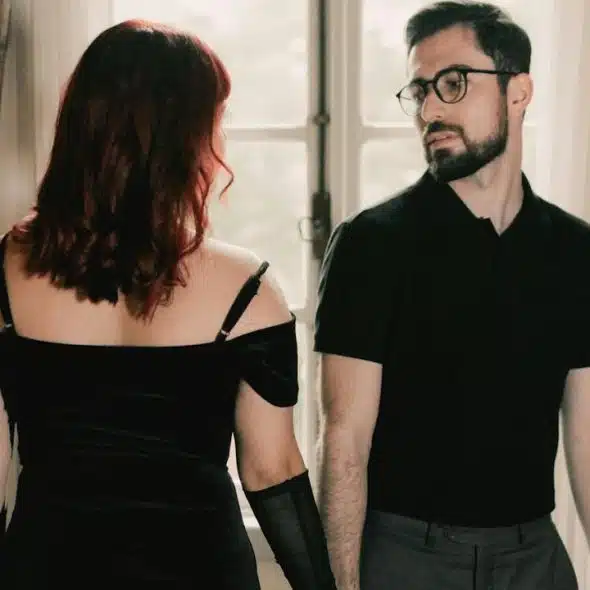 A man standing next to a woman in a black dress.