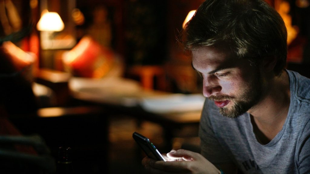 A close-up of a man using his phone.
