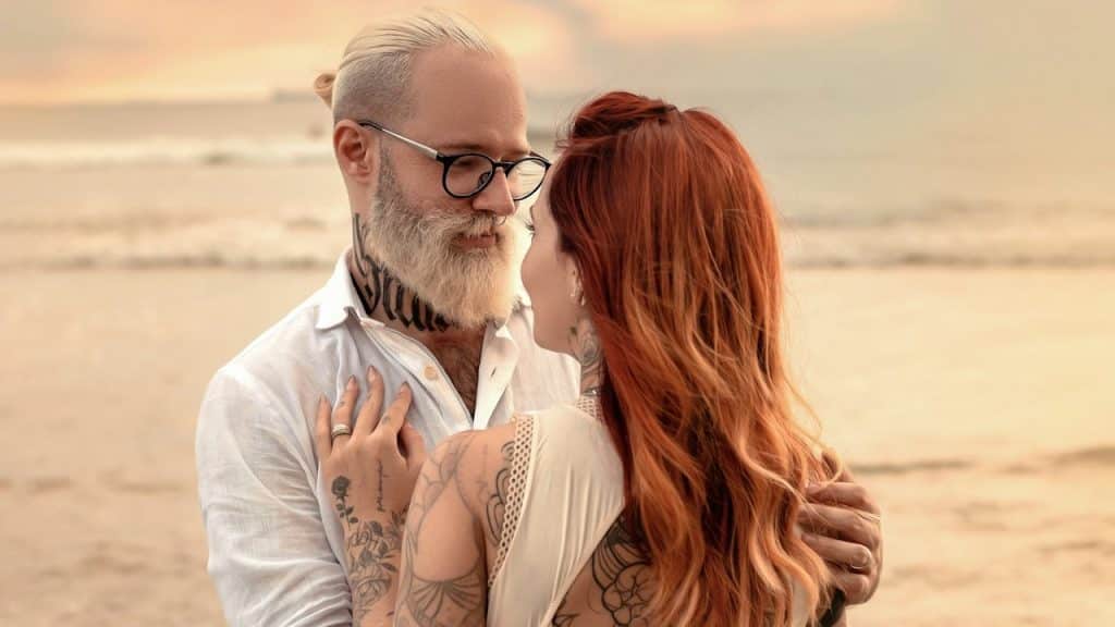 A man and woman hugging on a beach.