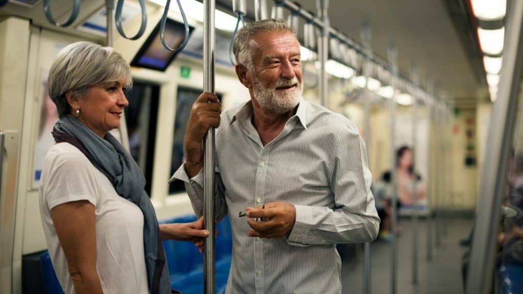 A senior couple traveling inside a train subway.