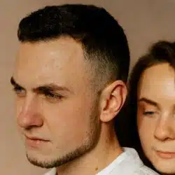 A man looking away from the woman standing beside him.