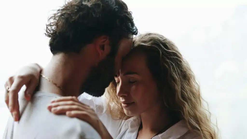 A couple with closed eyes touching foreheads and having a tender moment.